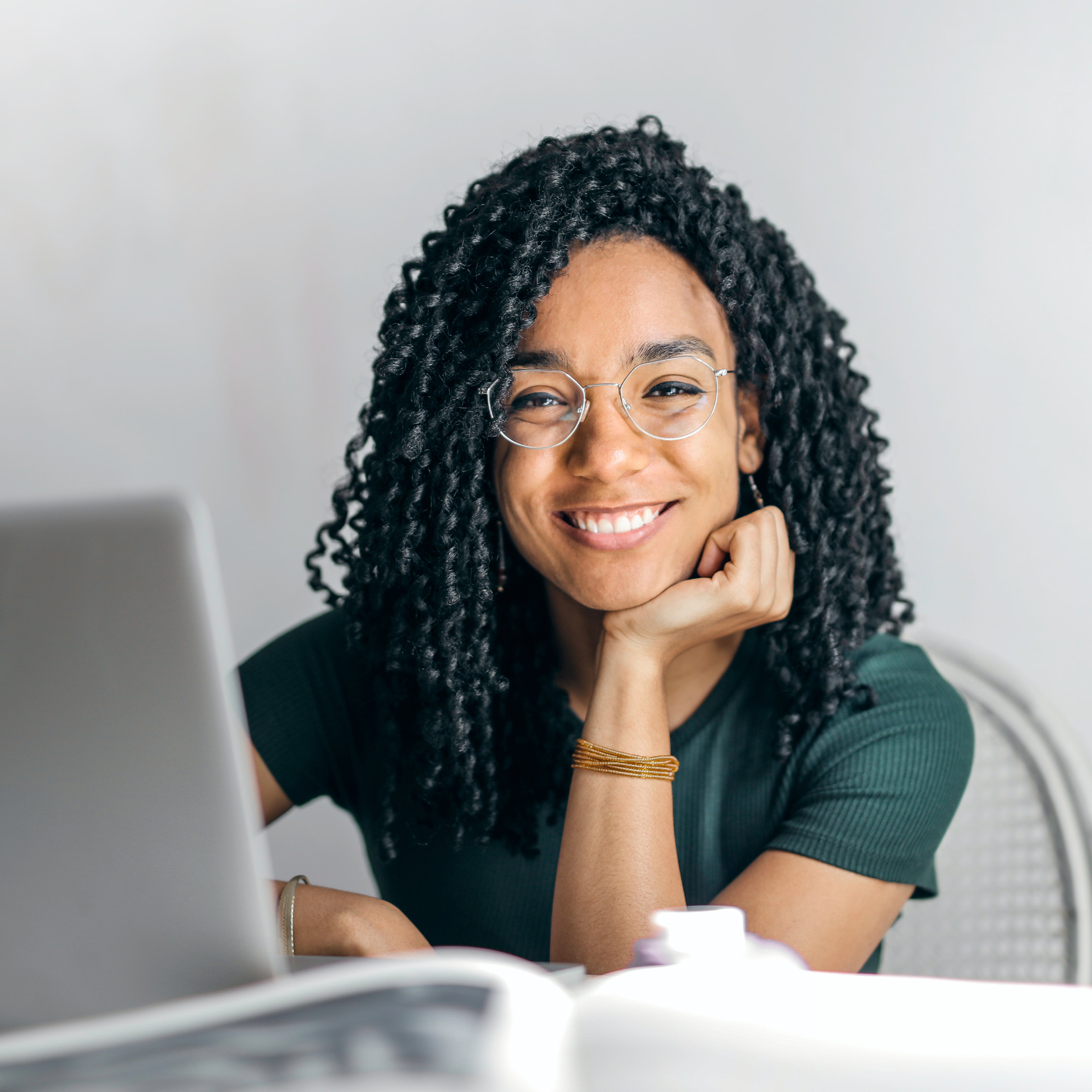 Dark haired woman sitting and smiling at camera